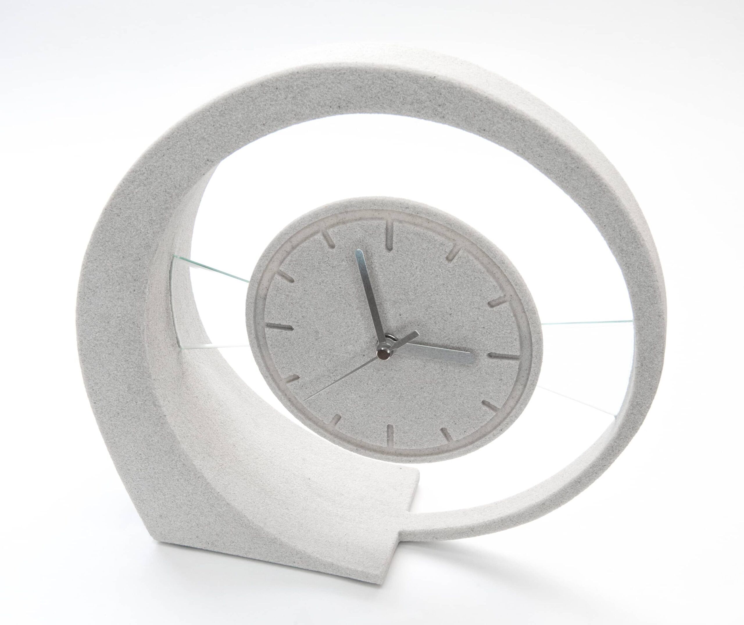 Design-Tischuhr „Susi“ aus Sandstein mit silbernen Zeigern, von vorne leicht schräg fotografiert.