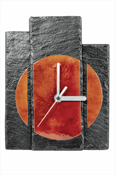 Detailansicht der Tischuhr Sundown von vorne, mit Fokus auf die silberfarbenen Metallzeiger und das Zusammenspiel von Schiefer und emailliertem Kupfer.